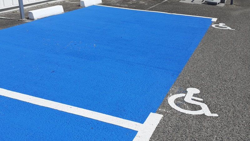 Marquage de places PMR en enduit et pose de sigle PMR réglementaire en thermocollé réalisés par Signalisation Routière Responsable Agenaise 47